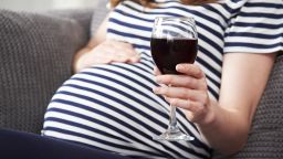 pregnant woman drinking wine STOCK