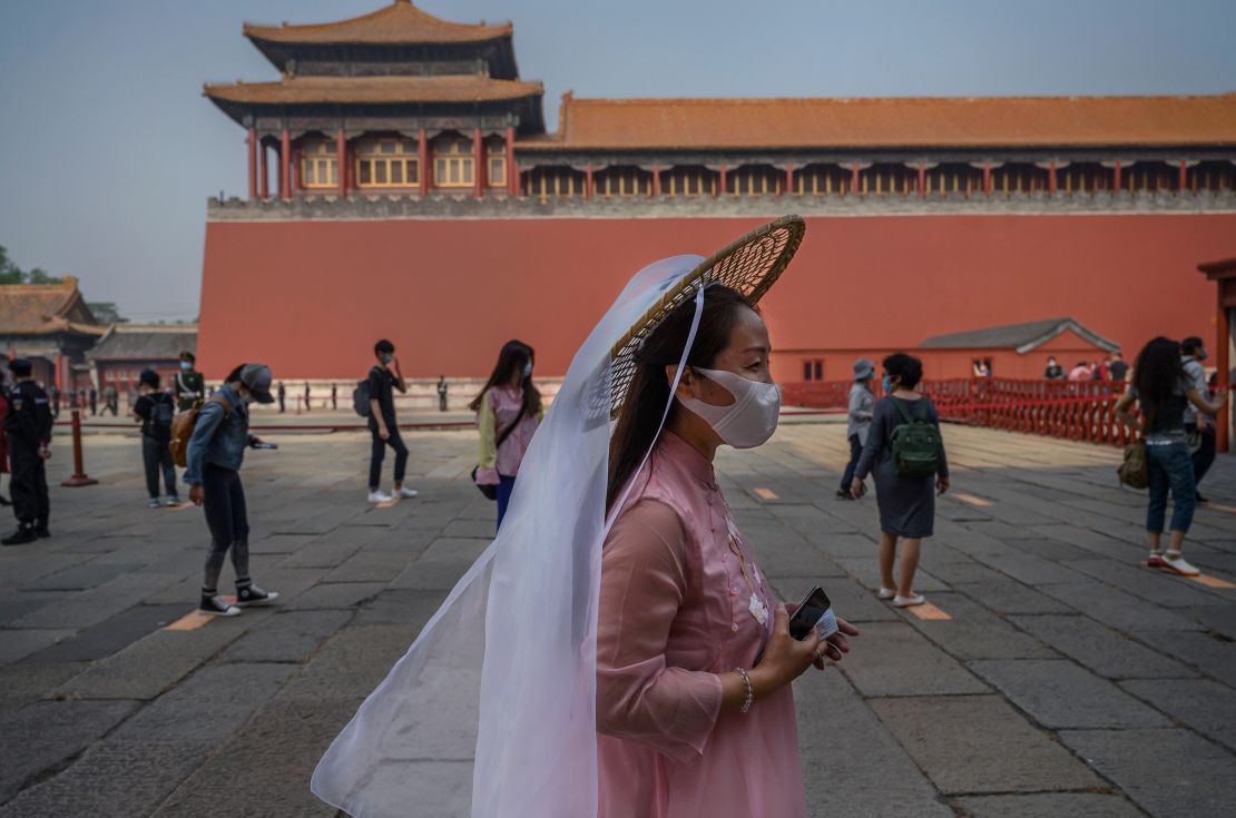 Chinese tourists wear protective masks as they line up to enter the Forbidden City.