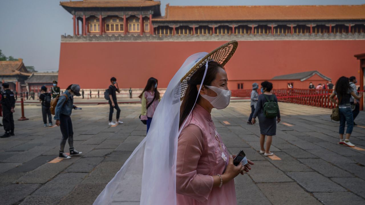 Chinese tourists wear protective masks as they line up to enter the Forbidden City.