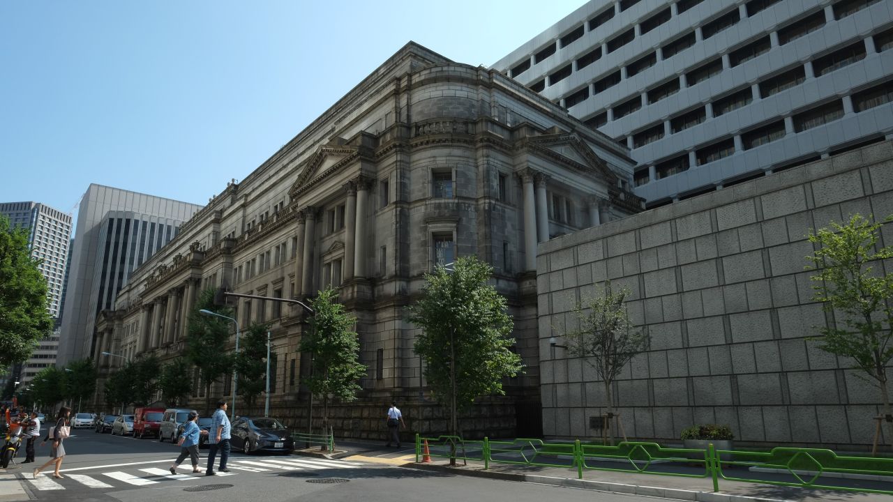 Pedestrians walk in front of the Bank of Japan headquarters in Tokyo on July 20, 2017.