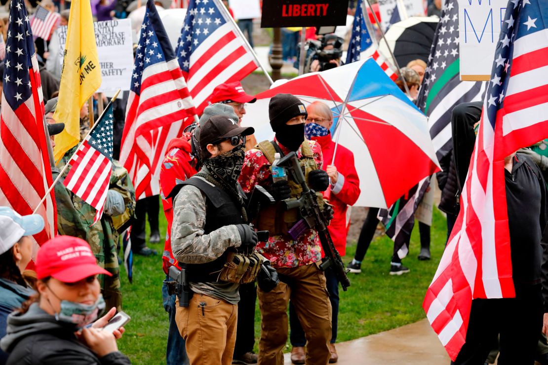 Armed protesters demand the reopening of businesses April 30, 2020, outside Michigan State Capitol in Lansing.