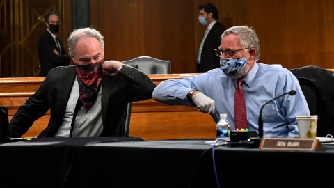 Sens. Tim Kaine of Virginia and Richard Burr of North Carolina greet each other with an elbow bump before the committee hearing on Tuesday. 