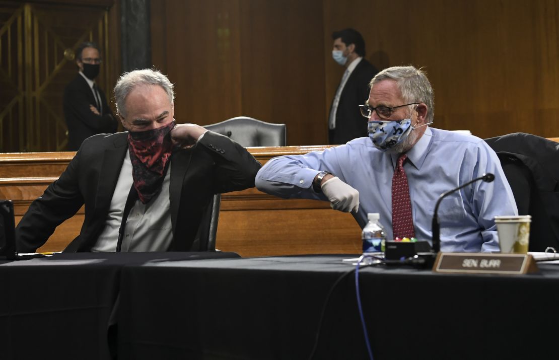 US Sens. Tim Kaine of Virginia and Richard Burr of North Carolina greet each other with an elbow bump.