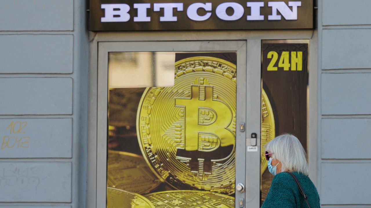 A lady wearing medical masks passes in front of a Bitcoin exchange shop in Krakow's city center. On Saturday, April 18, 2020, in Krakow, Poland. (Photo by Artur Widak/NurPhoto via Getty Images)