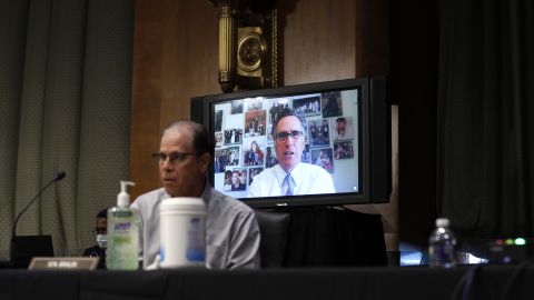Sen. Mitt Romney speaks via teleconference behind Sen. Mike Braun. "The President said the other day that President Obama is responsible for lack of vaccine. Dr. Fauci, is President Obama — or by extension President Trump — did they do something that made the likelihood of creating the vaccine less likely?" <a href="https://www.cnn.com/politics/live-news/fauci-testifies-coronavirus-05-12-2020/h_8b72e965e9227abdcef76327da4b499e" target="_blank">Romney asked.</a> Fauci said neither  Trump nor Obama are responsible for the lack of a coronavirus vaccine.