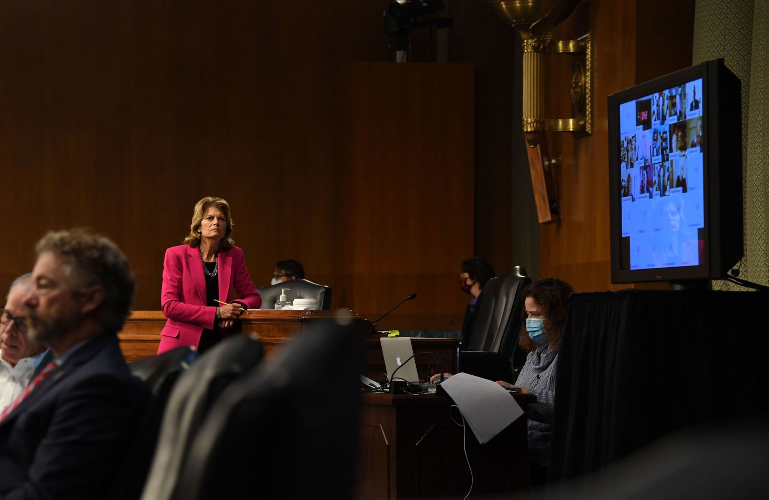 Sen. Lisa Murkowski stands to get a better view of Fauci's testimony.
