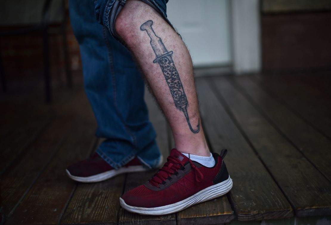 Eric, a recovering addict, shows off his syringe and hook tattoo at a recovery center in Huntington, West Virginia.