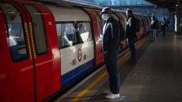 Passengers wear face masks and stand apart on a platform at Canning Town underground station in London. (Photo by Victoria Jones/PA Images via Getty Images)