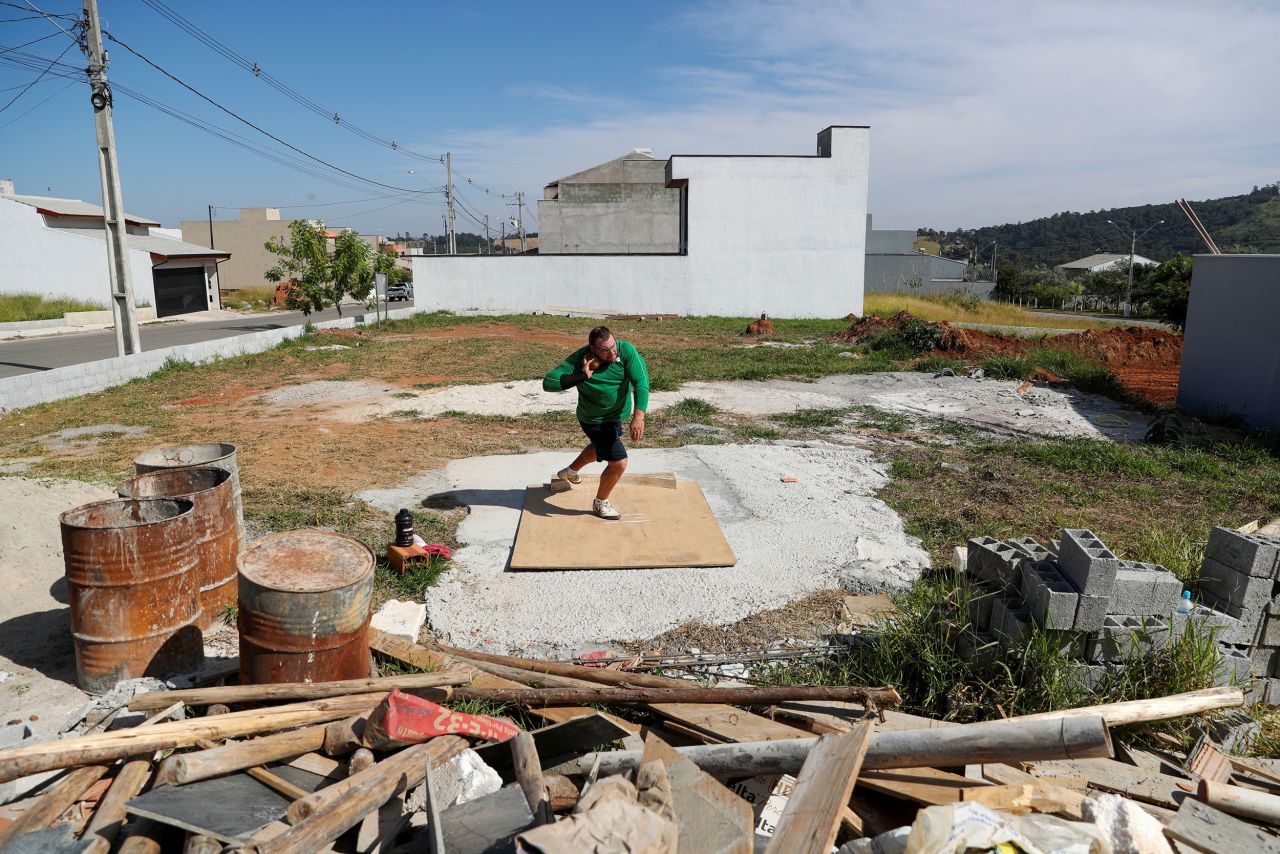 Darlan Romani practices the shot put at an abandoned field next to his house in Braganca Paulista, Brazil, on May 5.