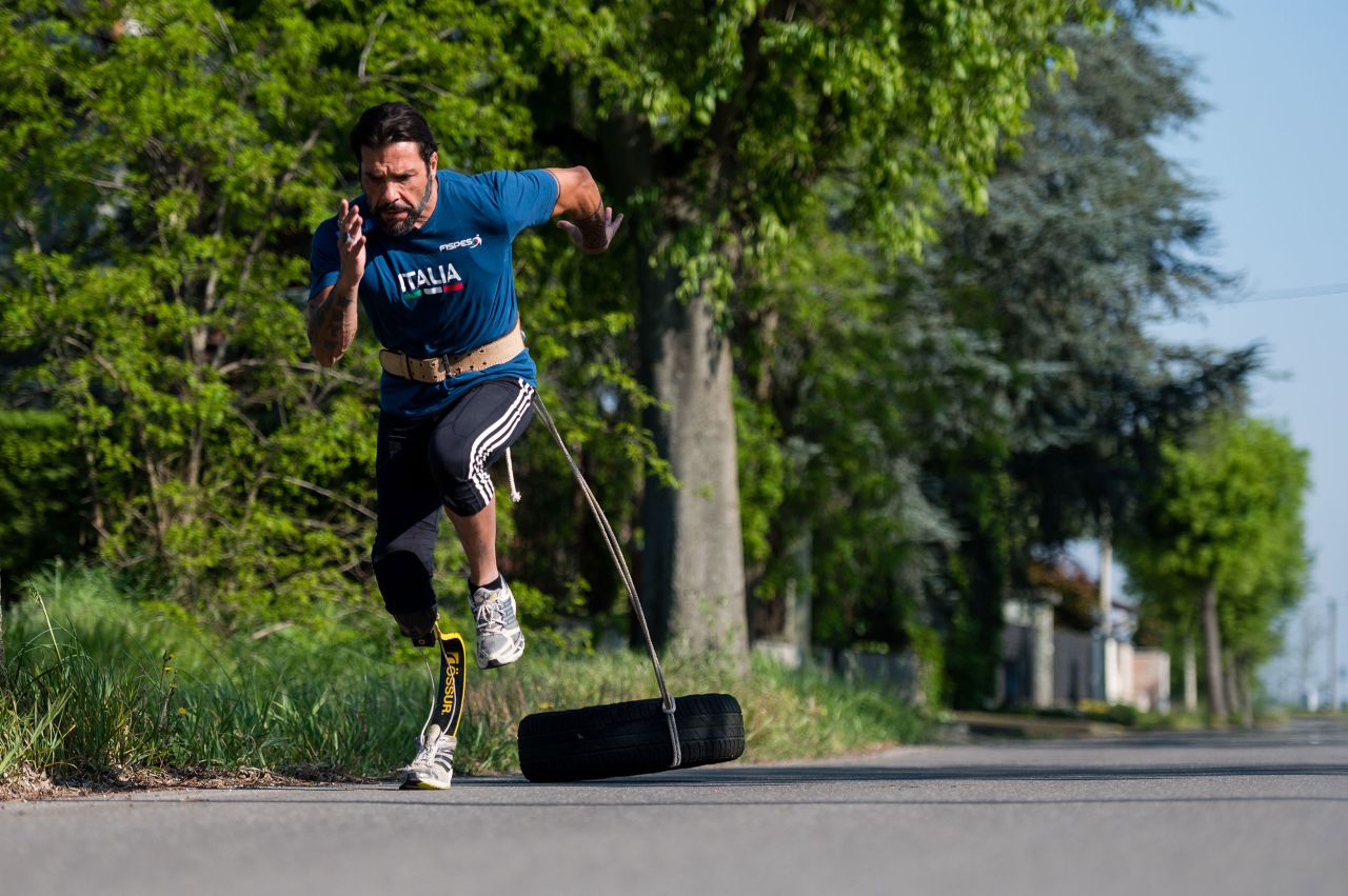 Paralympian Roberto La Barbera runs with a tire in Alessandria, Italy, on April 23.