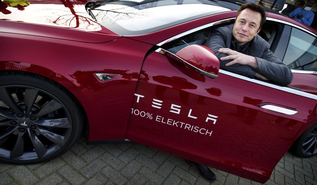 Musk poses with a Tesla during a visit to Amsterdam, Netherlands, in 2014.