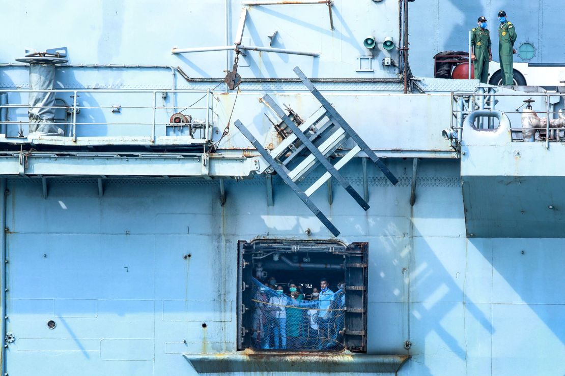 Indian citizens evacuated from Maldives look outside the Indian Navy INS Jalashwa ship as it arrives to Cochin port in Kochi on May 10, 2020.