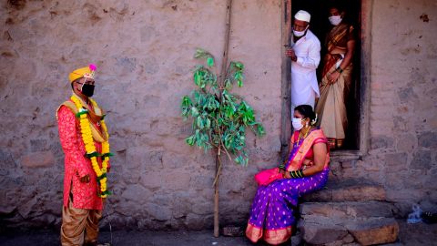 Groom Vitthal Koditkar, left, of Hirpodi village speaks with his bride Vrushali Renuse, right, of Pabe village and family members after their wedding during a government-imposed nationwide lockdown at Pabe village in Pune district in Maharashtra, India. 