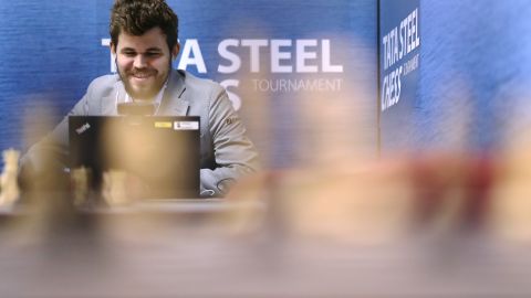 Carlsen speaks on his computer in a press room.