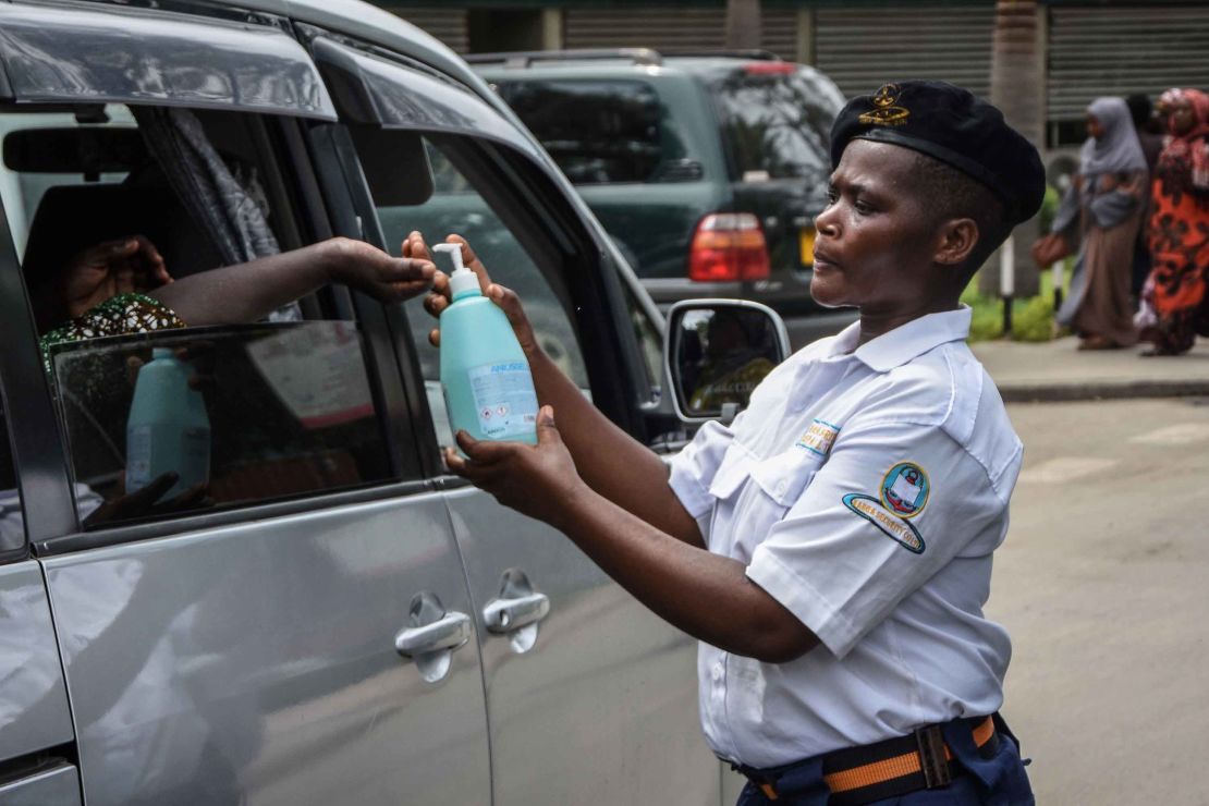 A security officer dispenses chlorinated water to a passenger at Muhimbili National Hospital in Dar es Salaam, Tanzania, a few hours after the government announces the first case of the Covid-19 in the country on March 16, 2020.
