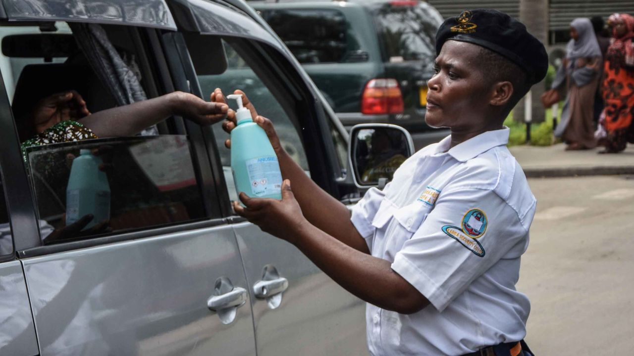 A security officer dispenses chlorinated water to a passenger at Muhimbili National Hospital in Dar es Salaam on March 16.