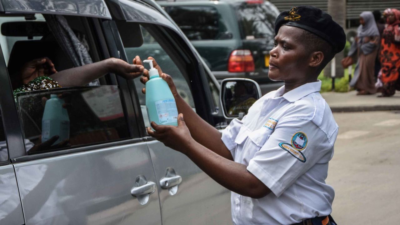 A security officer dispenses chlorinated water to a passenger at Muhimbili National Hospital in Dar es Salaam, Tanzania, a few hours after the government announces the first case of the Covid-19 in the country on March 16, 2020.