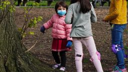 NEW YORK, NEW YORK - APRIL 25:  A child wearing a protective mask plays with other children in Central Park during the coronavirus pandemic on April 25, 2020 in New York City. COVID-19 has spread to most countries around the world, claiming over 203,000 lives lost with over 2.9 million infections reported. (Photo by Cindy Ord/Getty Images)