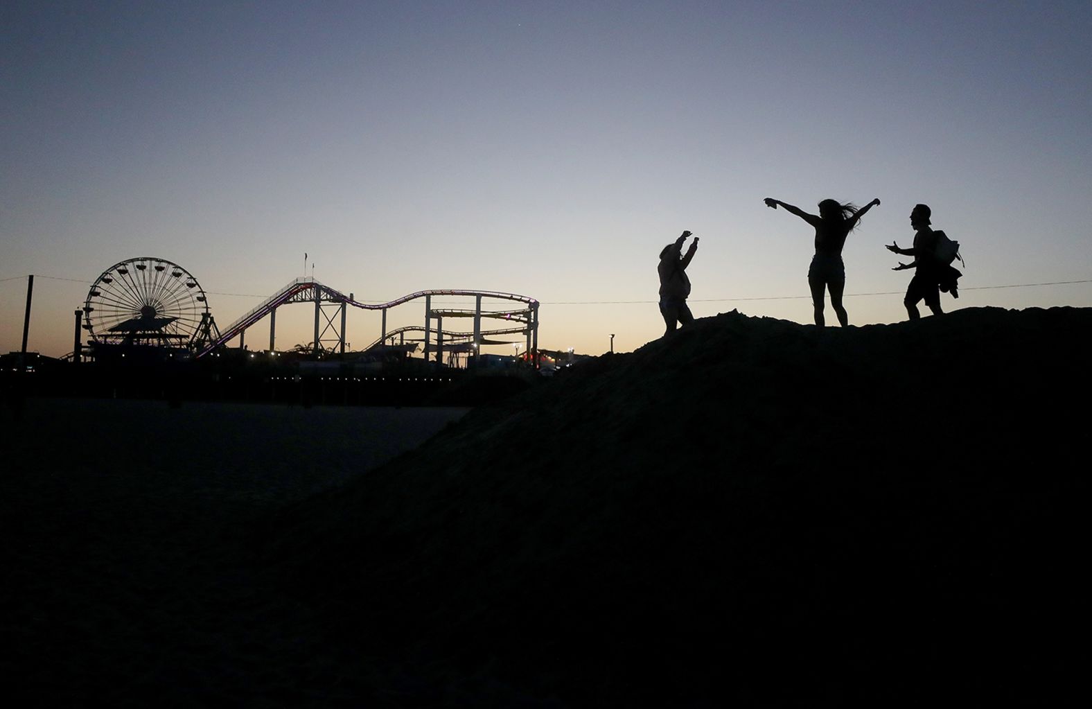 People dance at dusk on the beach in Santa Monica, California, on May 13. A stay-at-home order was still in place in Los Angeles County, but <a  target="_blank">some restrictions were modified.</a> Beaches opened for runners, swimmers and surfers, but not sunbathers.