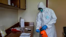 An Ugandan health officer prepares to take samples for testing a truck driver for COVID-19  in Malaba on April 29, 2020.