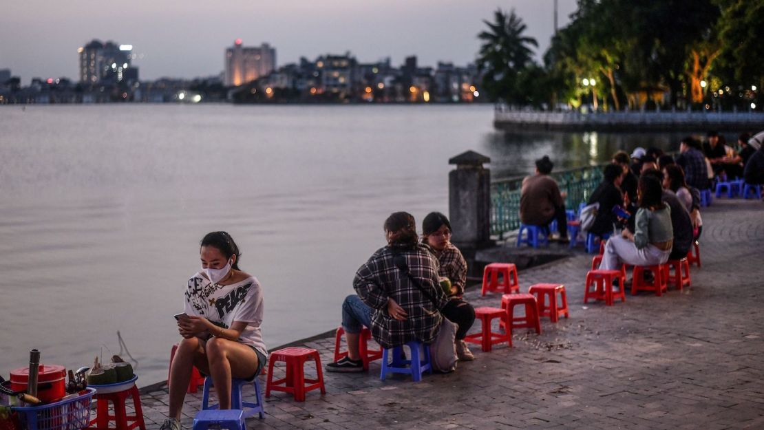 A woman sits by the lake at sunset in Hanoi on May 2.