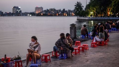 Groups of people sit by the lakeside at sunset in Hanoi on May 2.