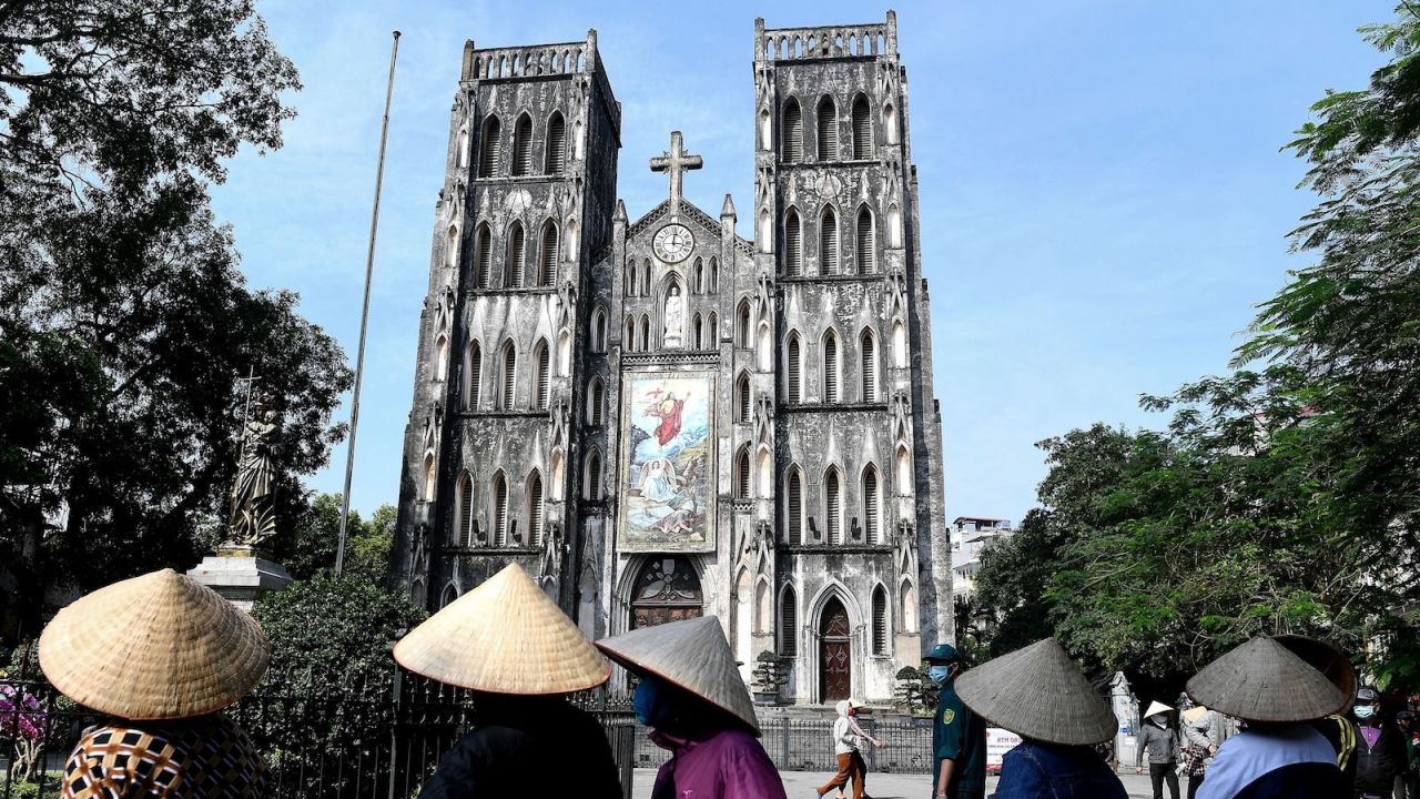 Residents wearing face masks practise social distancing as they stand in a queue for free rice at the St. Joseph's cathedral in the old quarters of Hanoi on April 27, 2020, after Vietnam eased its nationwide social isolation effort to prevent the spread of the COVID-19 novel coronavirus. - Vietnam eased social distancing measures on April 23, with experts pointing to a decisive response involving mass quarantines and expansive contact tracing for the apparent success in containing the coronavirus. (Photo by Nhac NGUYEN / AFP) (Photo by NHAC NGUYEN/AFP via Getty Images)