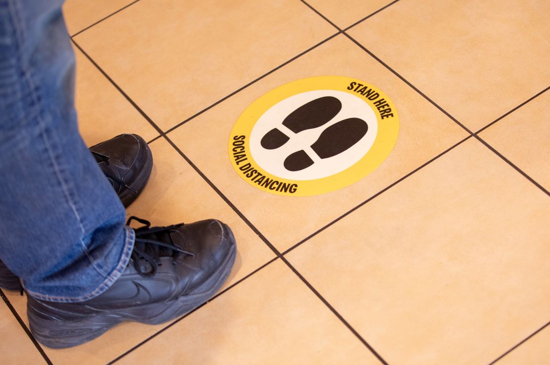 Floor decals should help space people out in stores. 