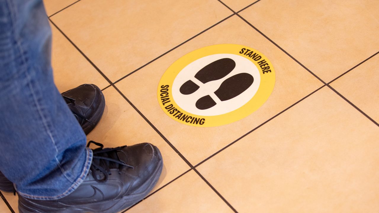Floor decals should help space people out in stores. 