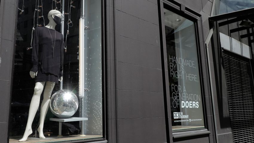 In this May 6, 2020 photo, a mannequin wears a mask in the window of the Do the Extraordinary clothing and accessories store in downtown Seattle, which is closed. Nearly all retail stores and restaurants in the area are currently closed or operating under reduced levels of service due to the outbreak of the coronavirus and state-wide stay-at-home orders, which has led to thousands of workers losing their jobs or being furloughed. (AP Photo/Ted S. Warren)