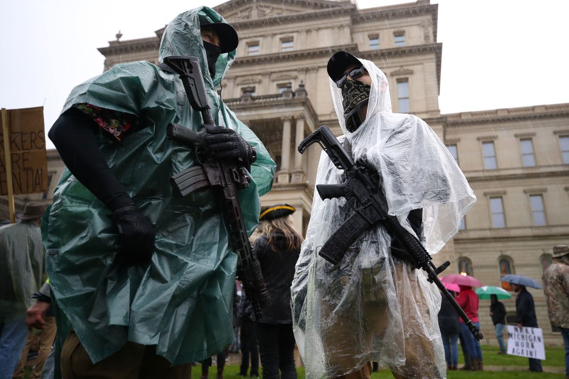 Protesters carrying weapons gather at the Michigan Capitol Building on May 14, 2020 in Lansing, Michigan.