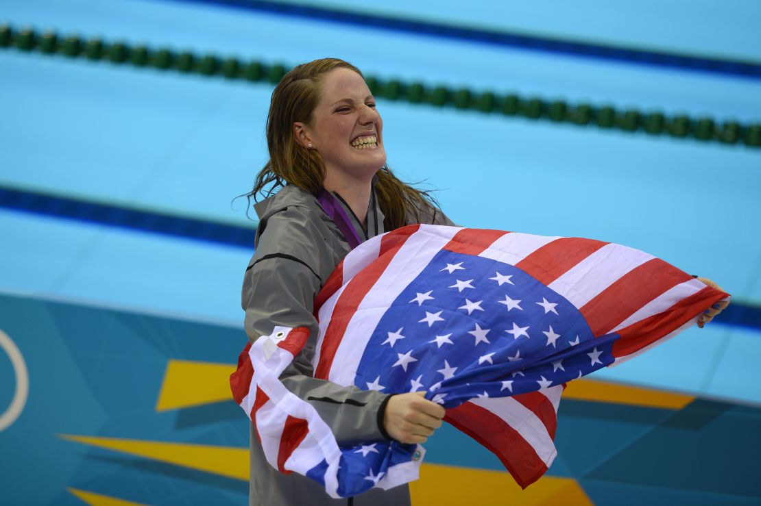 Franklin carries a US flag from the podium after recieving her gold medal for the women's 100-meter backstroke final at the London 2012 Olympic Games.