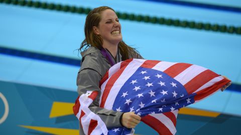 Franklin carries a US flag from the podium after recieving her gold medal for the women's 100-meter backstroke final at the London 2012 Olympic Games.