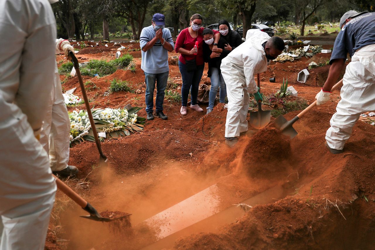 People in Sao Paulo, Brazil, watch as gravediggers bury a relative on Wednesday, May 13. <a href="https://www.cnn.com/2020/05/12/americas/brazil-coronavirus-sao-paulo-favelas-intl/index.html" target="_blank">The coronavirus has hit Brazil hard,</a> with the number of confirmed cases climbing by the thousands every day.