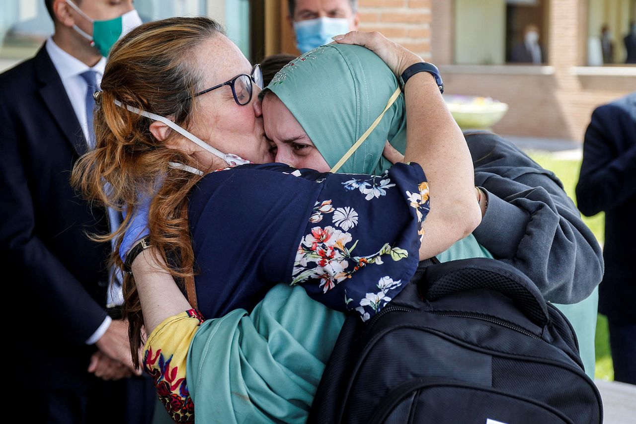 Silvia Romano, an Italian aid worker who was kidnapped by gunmen in Kenya 18 months ago, is kissed by her mother, Francesca Fumagalli, at a military airport in Rome on Sunday, May 10.