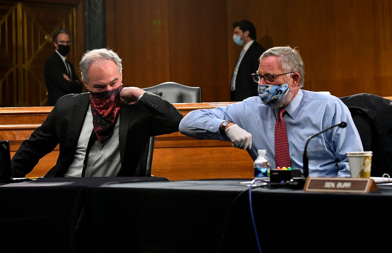 US Sens. Tim Kaine, left, and Richard Burr greet each other with an elbow bump before a committee hearing on Tuesday, May 12. <a href="https://www.cnn.com/2020/05/12/politics/gallery/senate-hearing-remote-witnesses/index.html" target="_blank">Some senators worked remotely,</a> including committee chairman Lamar Alexander, who is self-quarantining after a staff member at his office tested positive for Covid-19.