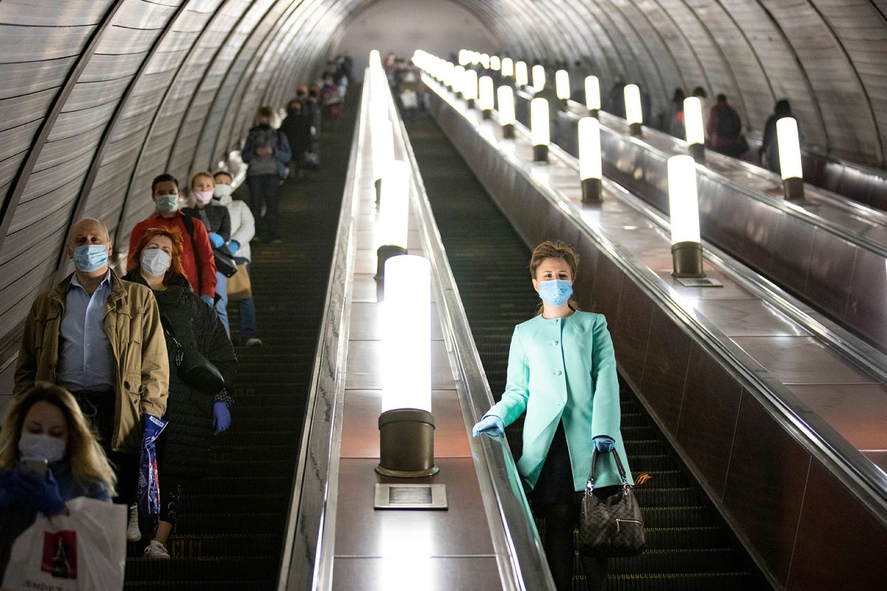 People observe social-distancing guidelines as they go down a subway escalator in Moscow on Tuesday, May 12. Masks and gloves are mandatory for people using Moscow's public transportation.