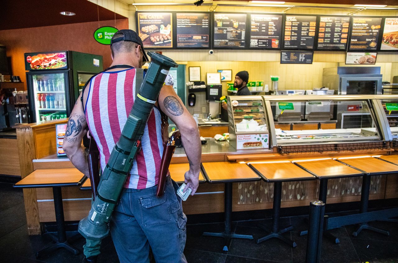 Steve Wagner carries an inert anti-tank weapon and two pistols <a href="https://www.newsobserver.com/news/local/article242628341.html" target="_blank" target="_blank">while paying for sandwiches at a Subway restaurant </a>in Raleigh, North Carolina, on Saturday, May 9. He was part of a group of about 11 demonstrators, mostly armed, who had been marching around downtown Raleigh protesting North Carolina's stay-at-home order.
