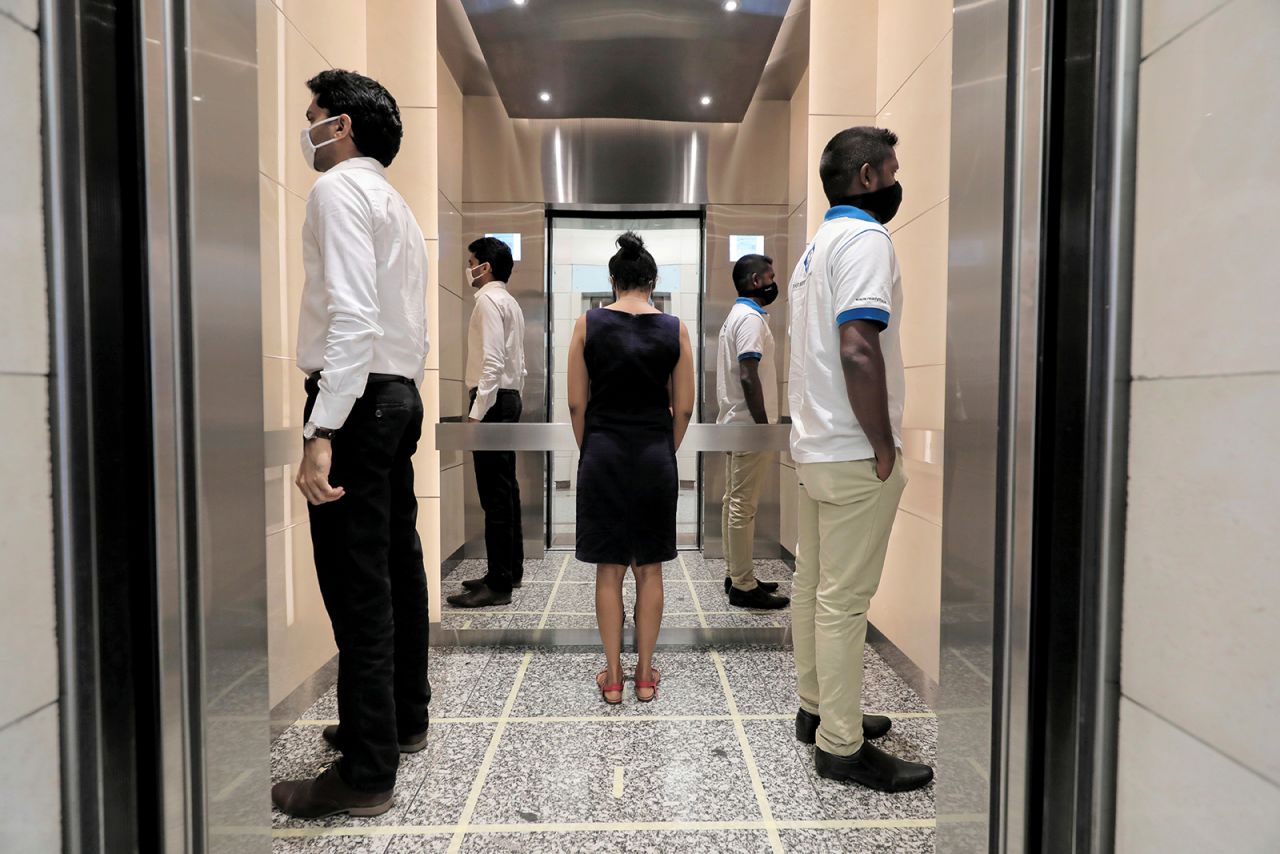 People in an elevator stand away from one another as they arrive to work at the World Trade Center in Colombo, Sri Lanka, on Monday, May 11.