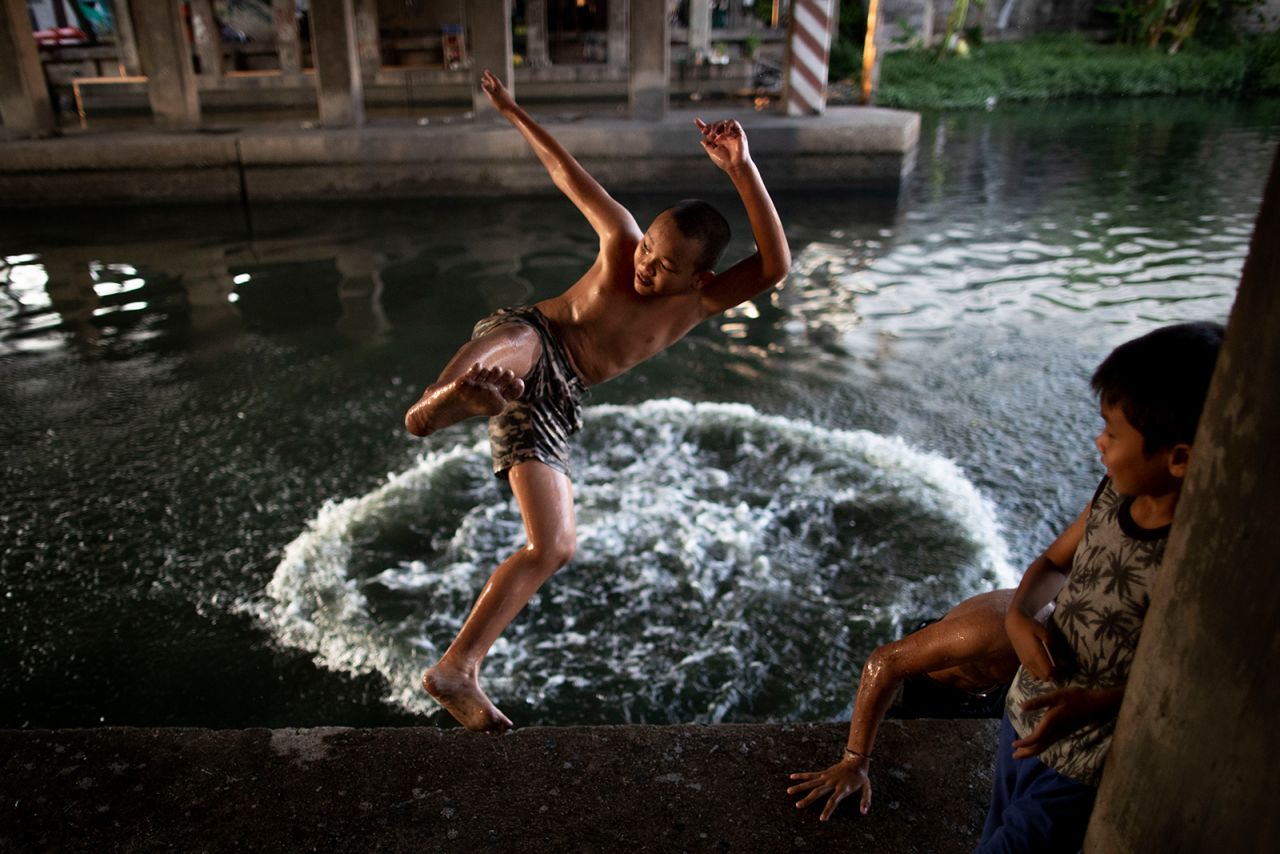 Children jump into a canal under an expressway in Bangkok, Thailand, on Tuesday, May 12.
