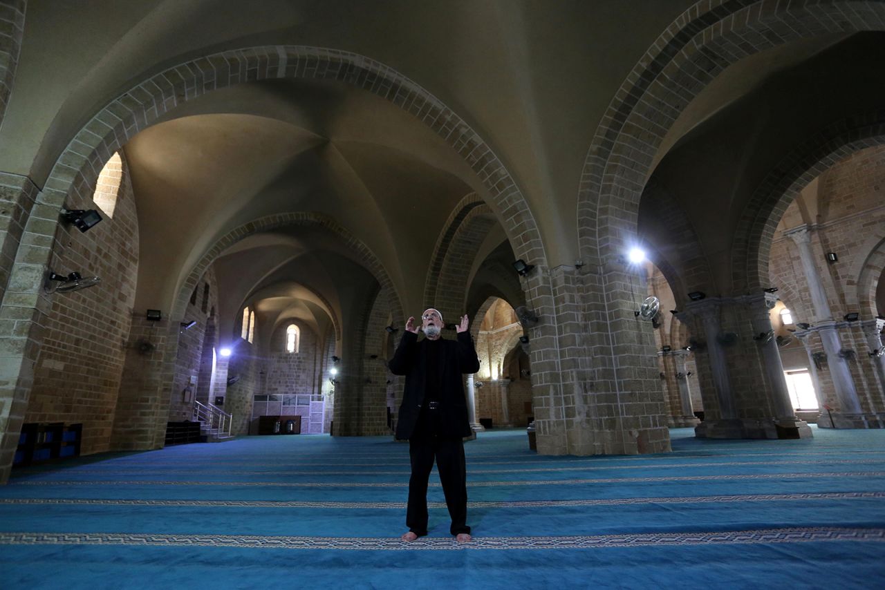 Muhammad Haniyyah prays alone in the Great Mosque of Gaza on May 14. He has been a mu'adhin — the person who leads and recites the call to prayer — at the mosque for 30 years.