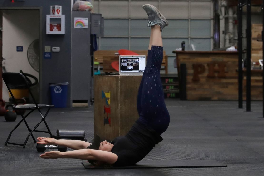 Alexis Garrod, CrossFit Potrero Hill partner and head coach, demonstrates an exercise to participants while instructing a class over Zoom in an empty gym in San Francisco in April. (Jeff Chiu/AP)