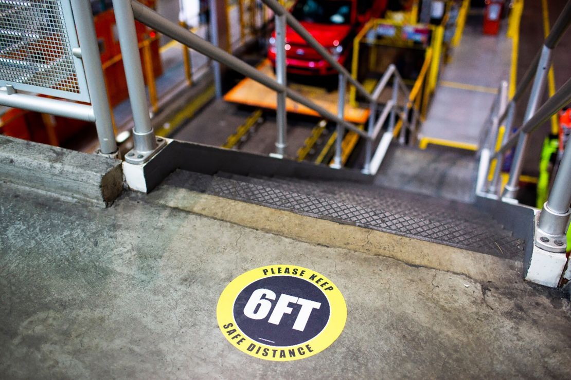 A marker inside a Ford factory reminds workers to keep enough distance from one other.