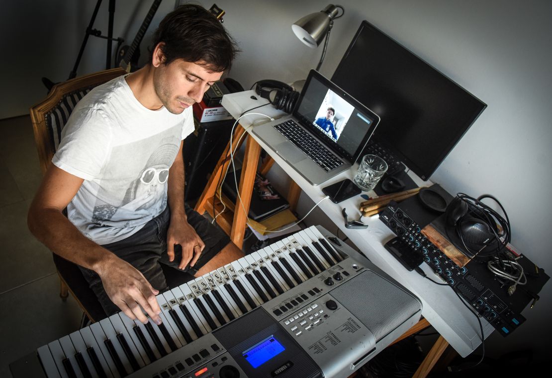 Musician Tati Diaz Bonilla plays the keyboard as a student listens and watches through Zoom during an online lesson from his apartment in Buenos Aires, Argentina.  (Marcelo Endelli/Getty Images)