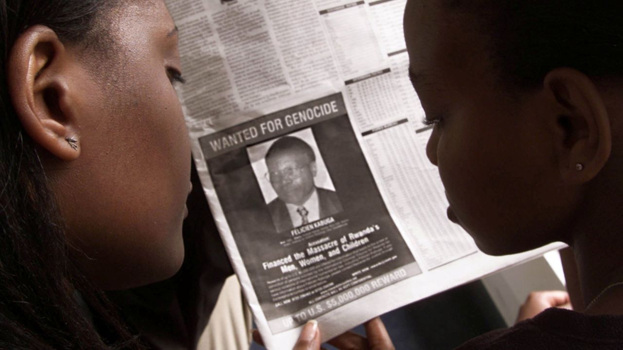 Readers look at a newspaper on June 12, 2002 in Nairobi carrying the photograph of Rwandan Felicien Kabuga.