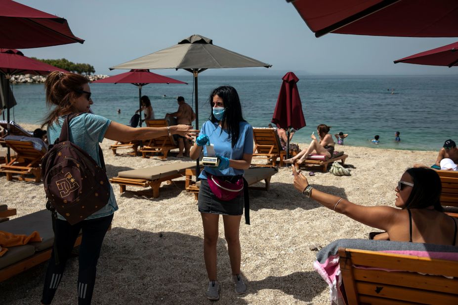 Swimmers pay for sunbeds at the Alimos beach near Athens, Greece, on May 16.