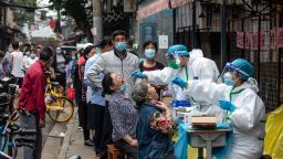 TOPSHOT - Medical workers take swab samples from residents to be tested for the COVID-19 coronavirus in a street in Wuhan in China's central Hubei province on May 15, 2020. - Authorities in the pandemic ground zero of Wuhan have ordered mass COVID-19 testing for all 11 million residents after a new cluster of cases emerged over the weekend. (Photo by STR / AFP) / China OUT (Photo by STR/AFP via Getty Images)