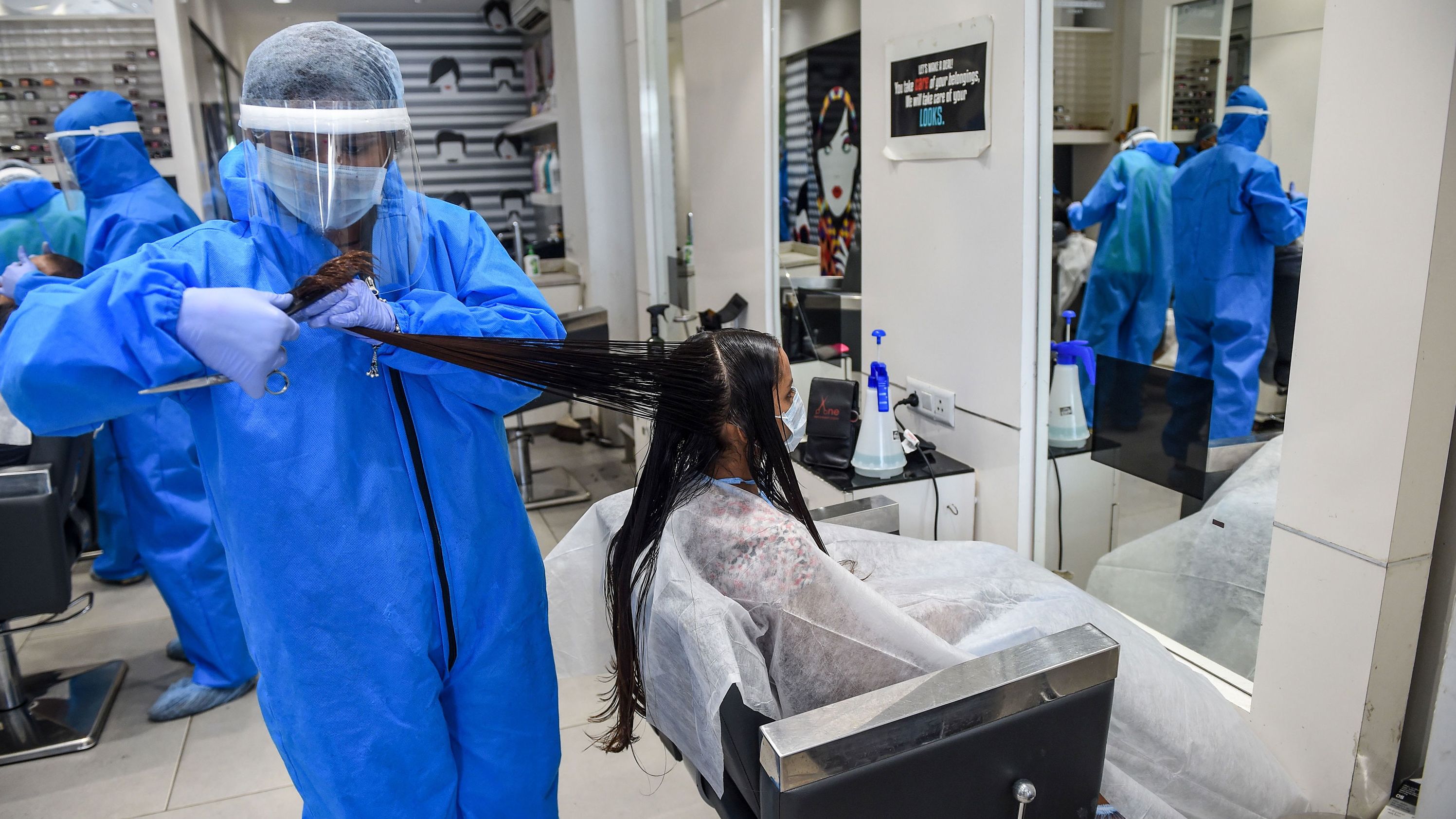 A worker wears protective gear while cutting a customer's hair at a salon in Nadiad, India, on May 17. India's lockdown was set to remain in place until May 31, but ma
