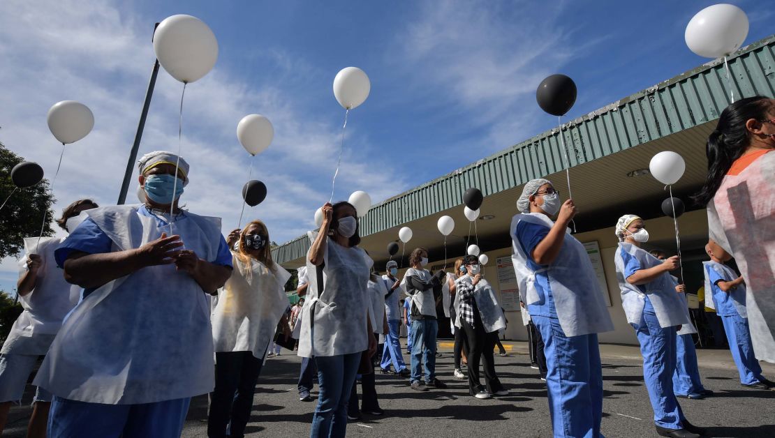 Health professionals hold balloons as they honour colleagues who have died of the coronavirus, outside Sao Paulo University Hospital.