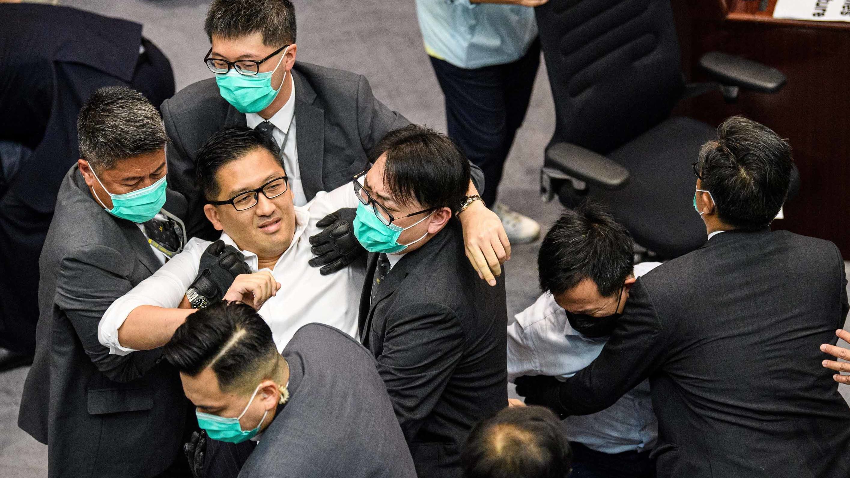 Lam Cheuk-ting is removed by security personnel following the scuffle.